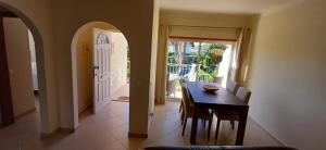a dining room with a table and chairs and a door at Casa Saudade - Oasis Parque Country Club in Portimão