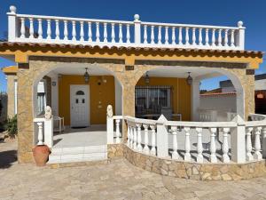 a house with an arch and a white fence at Turisblo villa carmen in Benicarló