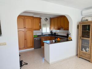 a kitchen with wooden cabinets and a counter top at Turisblo villa carmen in Benicarló +11 photos