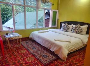 a bedroom with two beds and a window at Sohail home stay in Pahalgām