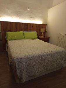 a bedroom with a bed with a green pillow at La Casa del Patio ATQ in Antequera