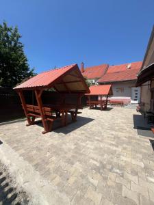 two picnic tables with a roof on a patio at Sólyom Szálló in Szombathely