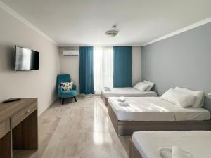 a hotel room with two beds and a tv at Woodline Hotel in Kemer