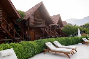 a resort with two lounge chairs and a building at Woodline Hotel in Kemer