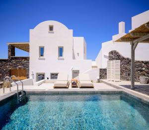 a pool in front of a white house at Avan Luxury Villas in Pyrgos