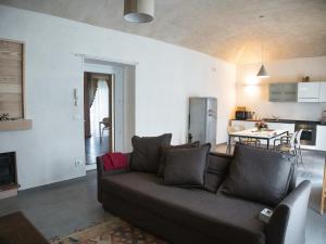a living room with a brown couch and a kitchen at Cascina della Contessa Suite in Roccaforte Mondovì