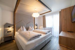 una camera da letto con un grande letto e un grande specchio di Hotel Alpenblick a Filzmoos