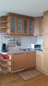 a kitchen with wooden cabinets and a sink and a microwave at Ker Stella in Plérin