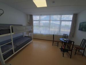 a bedroom with bunk beds and a table and chairs at Zirbitzblick in Zeltweg