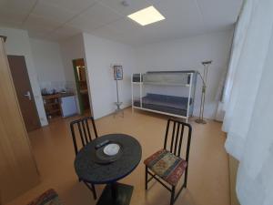 a room with a table and chairs and a bed at Zirbitzblick in Zeltweg