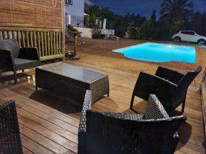 a wooden deck with chairs and a swimming pool at Lazy Tilapia in Baie du Tombeau