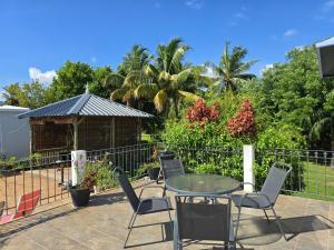 a patio with chairs and a table and a gazebo at Lazy Tilapia in Baie du Tombeau