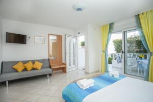 a bedroom with a bed and a couch and a balcony at Apartments Barbara in Trogir +20 photos