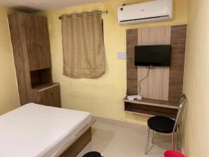 een kleine kamer met een bed en een televisie bij Hotel star in Rānchī