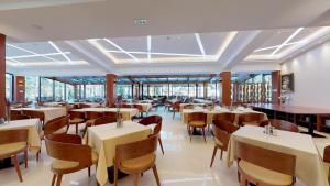 a restaurant with tables and chairs and windows at Time Out Lux apartmani in Zlatibor