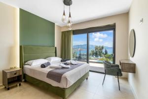 ein Schlafzimmer mit einem Bett und einem großen Fenster in der Unterkunft Ionian Hospitality Resort Suites & Villas in Nikiana + 289 Fotos