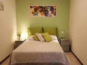 ein Schlafzimmer mit einem Bett mit zwei Tischen und einem Gemälde in der Unterkunft B&B La Canzanella in Neapel