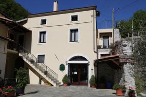 a large white building with stairs leading up to it at Agriturismo Dai Marchesin in Nasino