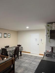a dining room with a table and chairs and a door at Santino Apart in Puerto Iguazú