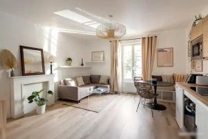 un salon avec un canapé, une table et des chaises dans l'établissement Logement St Malo Centre - Emplacement idéal 20 min à pied Intra-Muros & grande plage du Sillon, à Saint-Malo