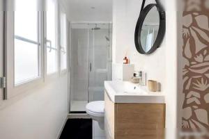 une salle de bain avec toilettes, lavabo et miroir dans l'établissement Logement St Malo Centre - Emplacement idéal 20 min à pied Intra-Muros & grande plage du Sillon, à Saint-Malo