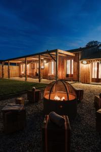 Un gran edificio con una fogata en frente. en La Cabane du Naissain 5 stars, en Saint-Georges-dʼOléron