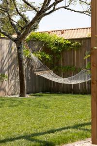 una hamaca en un patio junto a una valla en La Cabane du Naissain 5 stars, en Saint-Georges-dʼOléron 6 fotos más