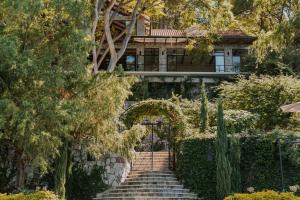 a home with a staircase leading up to a house at Luxury Lakefront Retreat at Casa Floresta in San Marcos La Laguna