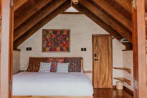 a bedroom with a bed in a room with wooden ceilings at Luxury Lakefront Retreat at Casa Floresta in San Marcos La Laguna