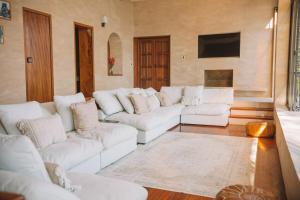 a living room with white couches and a television at Luxury Lakefront Retreat at Casa Floresta in San Marcos La Laguna