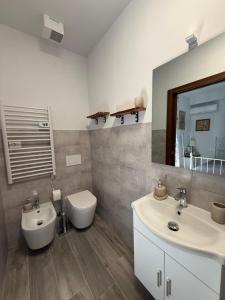 a bathroom with a sink and a toilet and a mirror at Villa Casavecchia Caselli in Dicomano