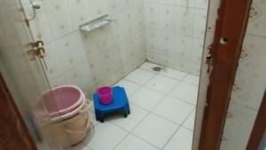 a small bathroom with a blue stool and a toilet at Milan, Khatushyamji in Khātu