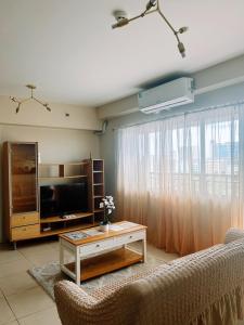 a living room with a tv and a couch at Spacious 3 Bedroom Appartement @Avida Allgauers in Iloilo City +22 photos