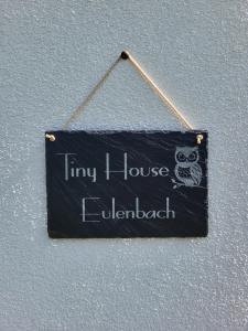 a sign hanging on a wall with an owl at Tiny House Eulenbach - Urlaub im Gletscherkessel Präg in Todtnau