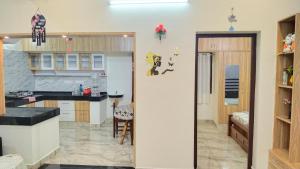 a kitchen with a counter and a dining room at RMS Homestay Madurai in Madurai