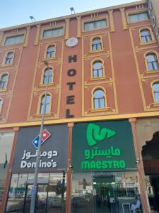 a building with a sign in front of a store at فندق ياسر الضلعي لى ريلاكس الفندقية-YASER ALDHILAY LE RELAX HoTEL in Buqayq