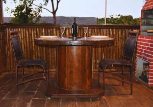 a wooden table with two chairs and a bottle of wine at Cabana Serra Fria in Palmas