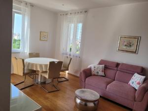 a living room with a purple couch and a table at Mary in Zadar