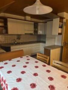 a kitchen with a bed with red roses on it at Appartamenti Famiglia Rizzi in Campitello di Fassa