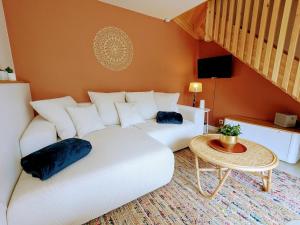 a living room with a white couch and a table at La Rue Perdue - Gîte & Spa in La Réole