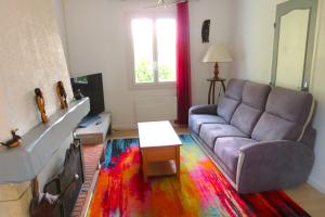 a living room with a couch and a colorful rug at le toucan in Azerables