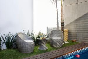 three wicker chairs sitting next to a swimming pool at Casa Bowie, Comfort y Descanso in Cuautla Morelos