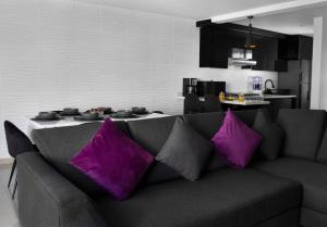a living room with a couch with purple pillows at Casa Bowie, Comfort y Descanso in Cuautla Morelos