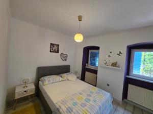 a small bedroom with a bed and a window at Kali in Kukuljanovo