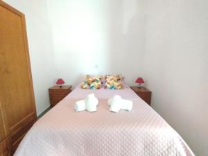 Un dormitorio con una cama con dos animales de peluche encima. en Casa Victor, en São Brás de Alportel 36 fotos más