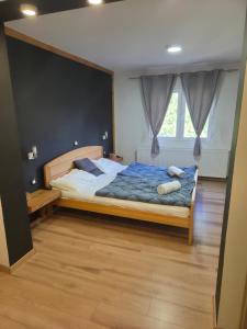 a bedroom with a large bed with a blue comforter at Country house Plitvice in Plitvica selo