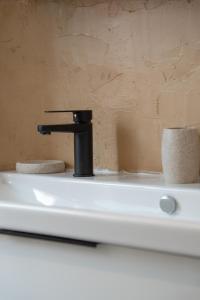 a black faucet on top of a toilet at La Marquise des Anges in Martel