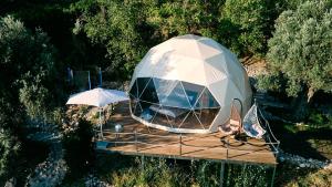 an igloo with chairs and an umbrella on a wooden deck at GO Glamping in Dobra Voda