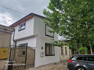 a white house with a car parked in front of it at Casa Rahova in Brăila