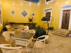 a dining room with tables and chairs and a yellow wall at MUSLIMA HOTEL Boutique in Bukhara